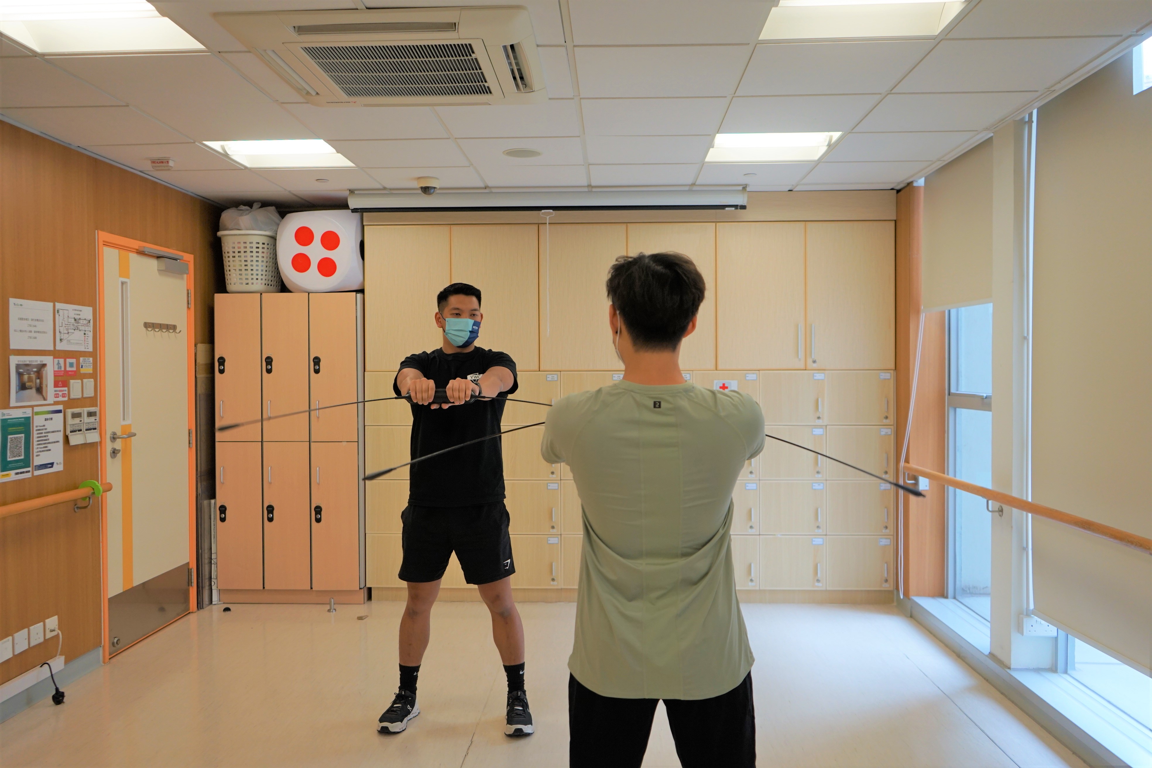 a physical fitness trainer and a man having bodyblade lesson