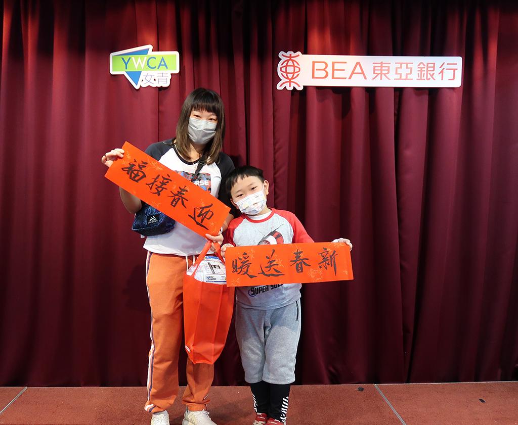 一位女士與男童一起領取食物福袋。