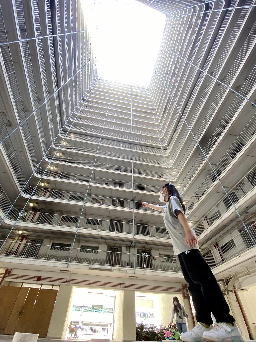 活動要求參賽者在指定時間內鬥快鬥多到訪區內多個地點，一名參加者在沙田舊式井字型屋邨拍照留念。