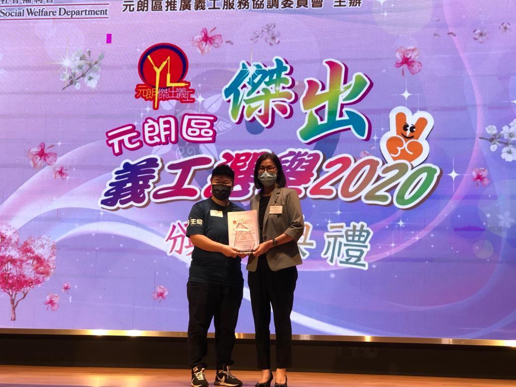 元朗區傑出義工選舉2020新秀組冠軍林穎彤從頒獎者手中接過獎狀。