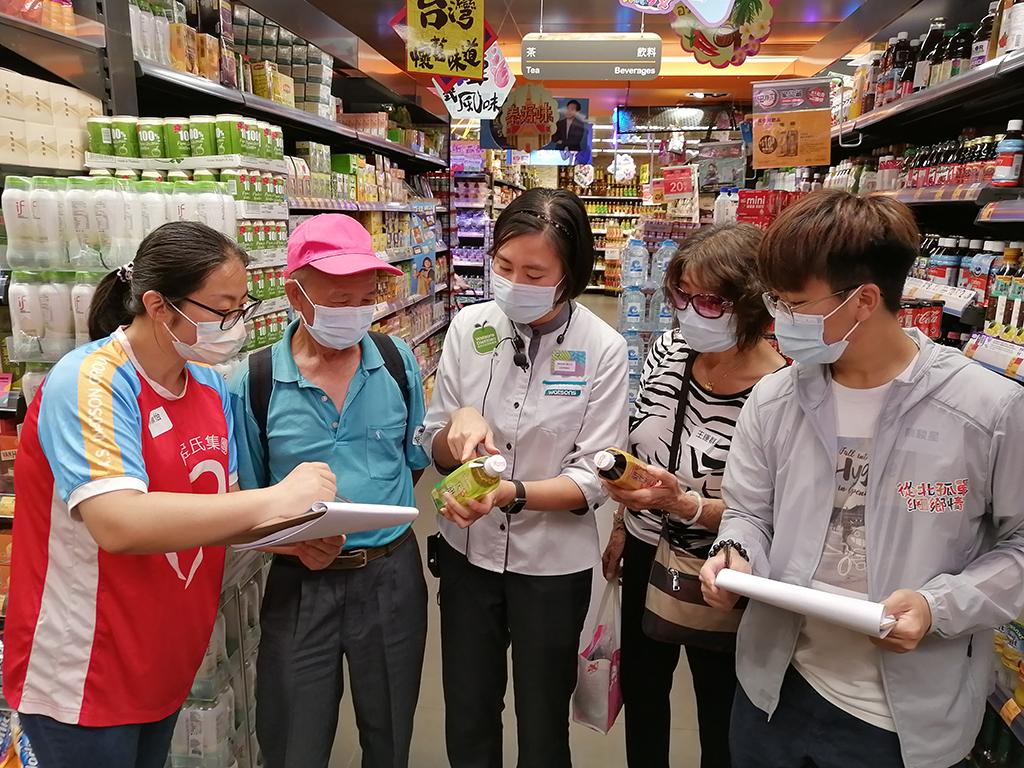 一名老伯在屈臣氏集團義工和營養師的陪同下，在粉嶺fusion超市內認識食物包裝上的營養標籤。