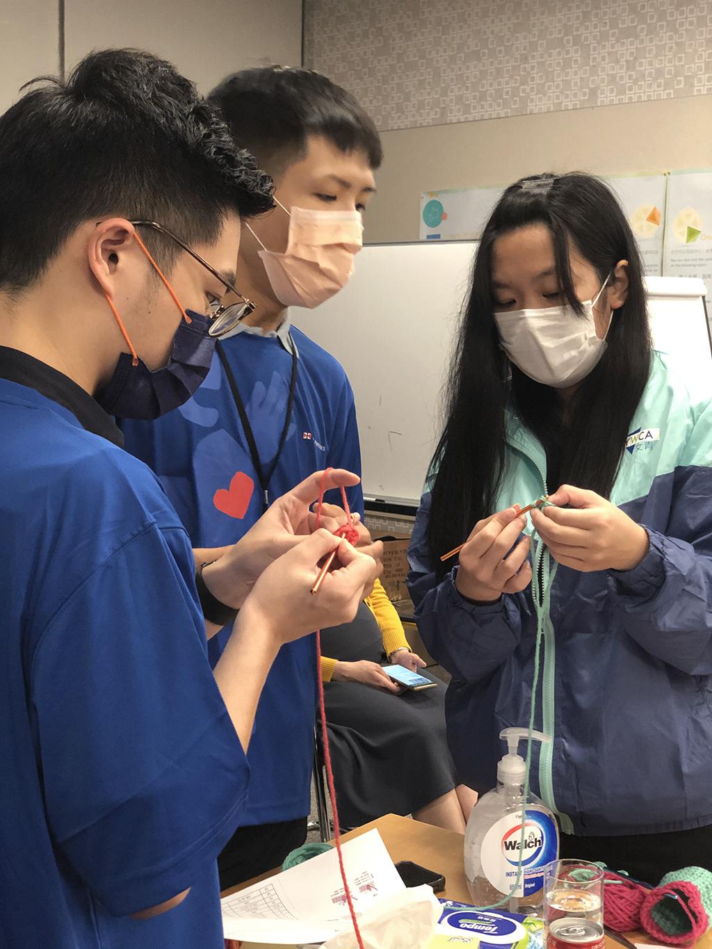 一位年青媽媽教導太古愛心大使義工如何編織鈎織作品。