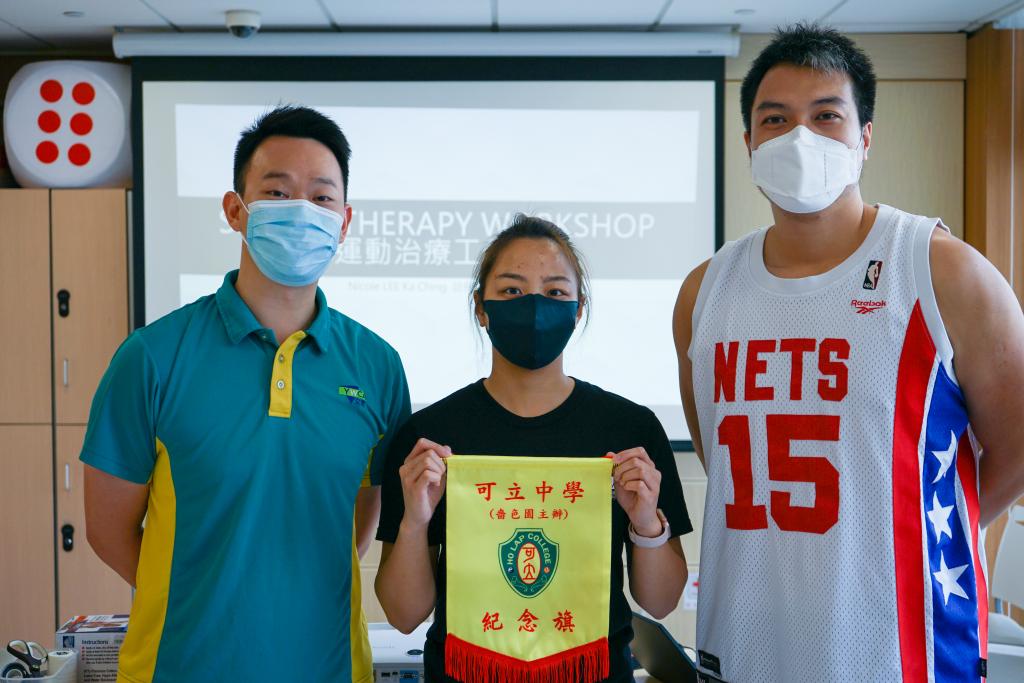 女青適健中心的物理治療師和運動治療師接受可立中學頒贈的錦旗。