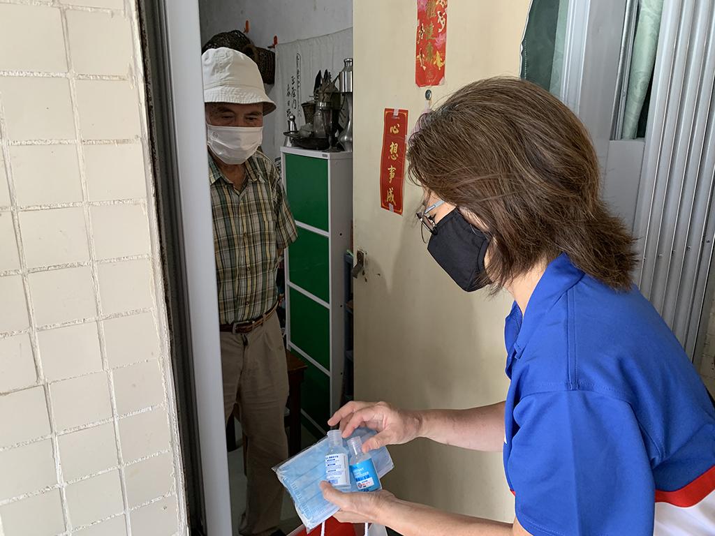 手持口罩及消毒液的義工前往龍田邨探訪獨居長者。