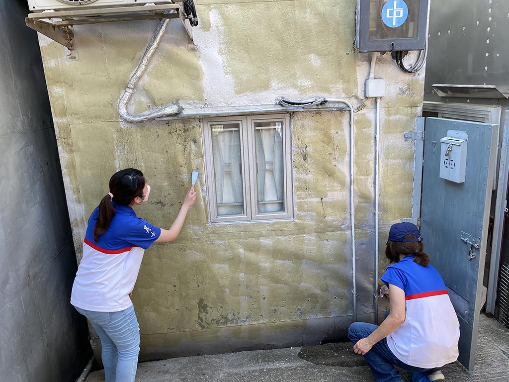 兩名其士集團女義工協助大澳棚屋完成外牆批盪工程。