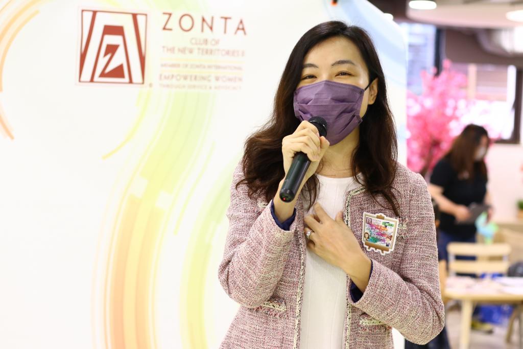 一名長髮女士手持咪高峰講話。