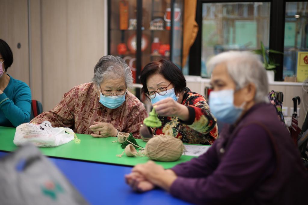 2 elderly review the crochet products on their hands.