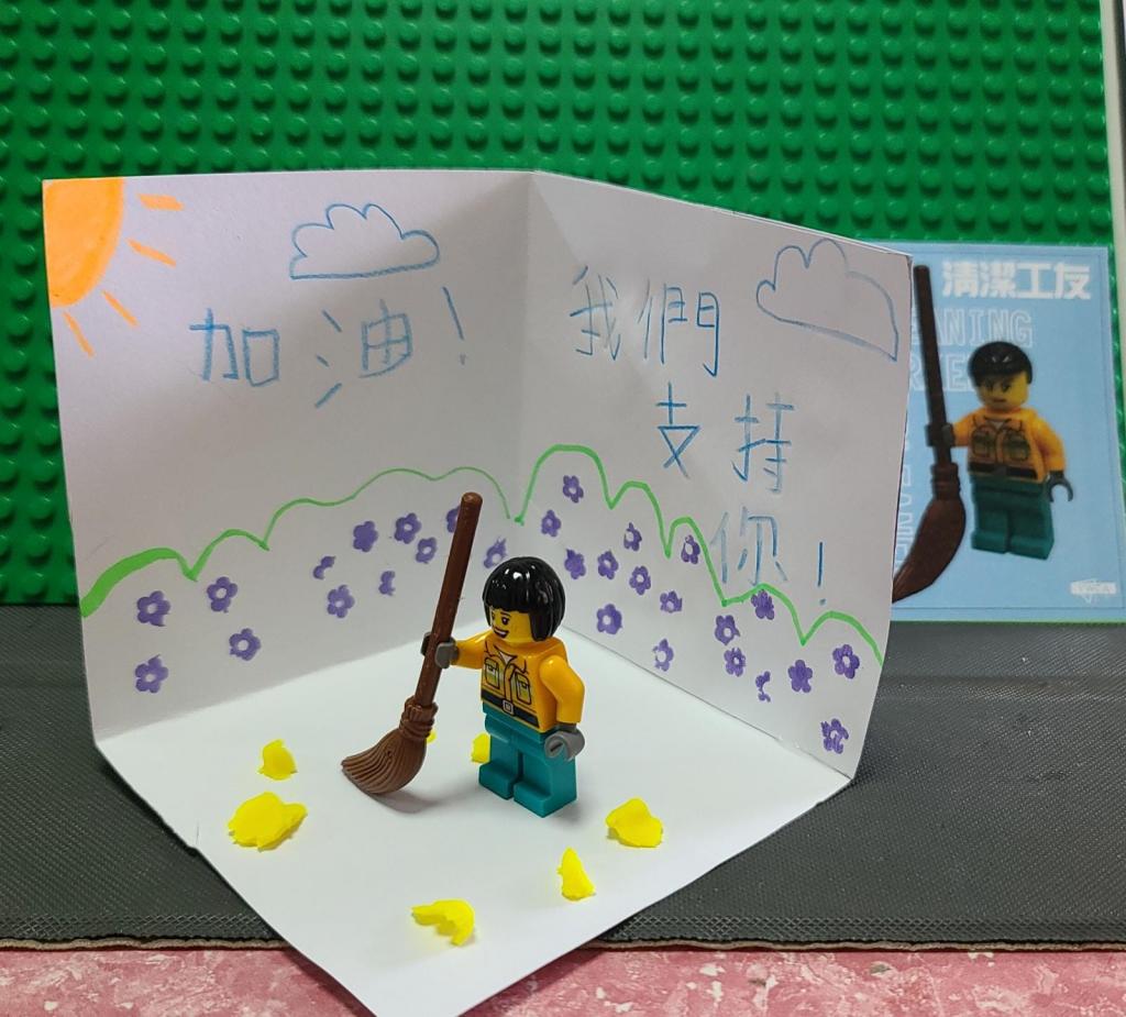 A miniature with brick figure, hand drew scene and the caring message from a kid.
