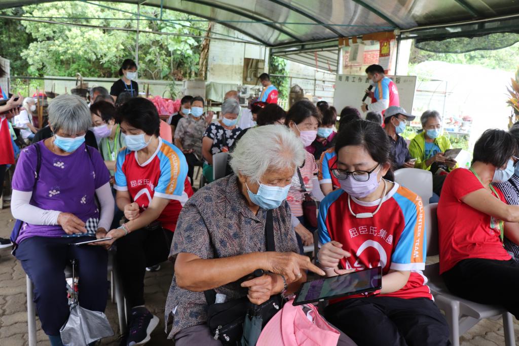a volunteer show an elderly how to use tablet