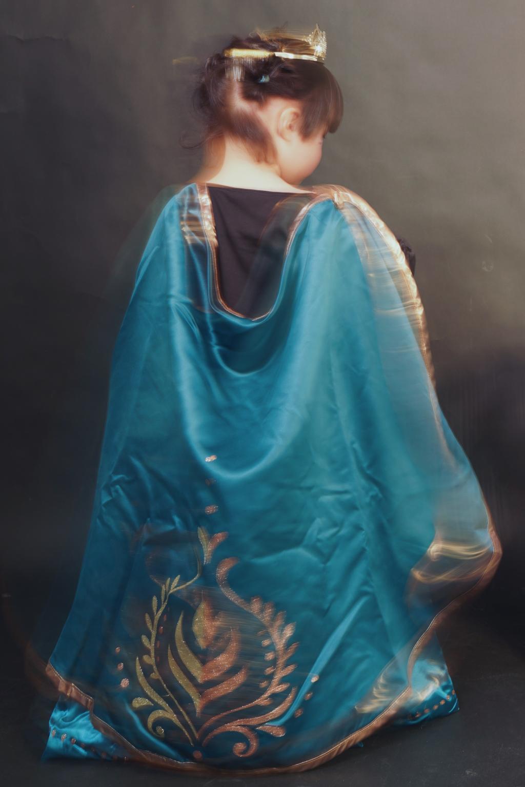 photo of the back of a little girl dressed in turquoise