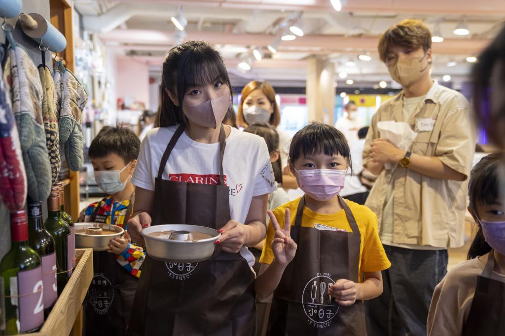 一名女義與小孩拿著蛋糕模具。