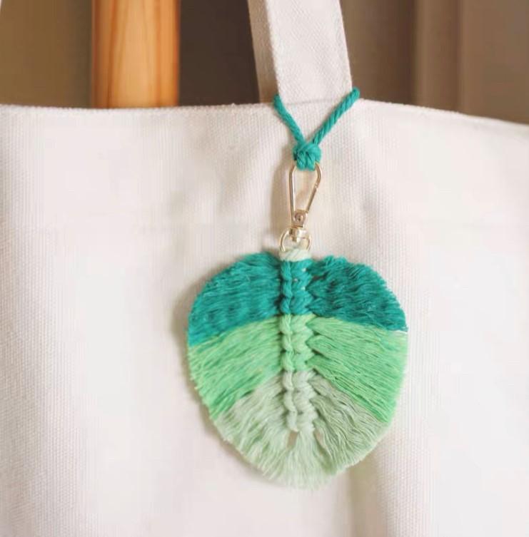 A feather key ring tagged in a white tote bag.