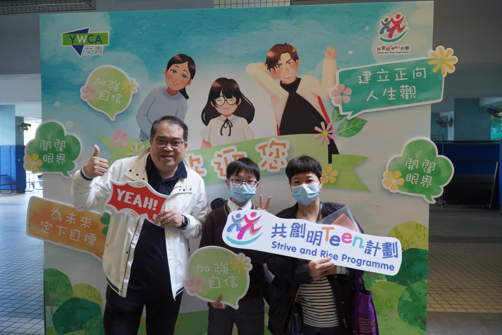 學員、家長與友師於印有藍天白雲青草地的活動背板前合照