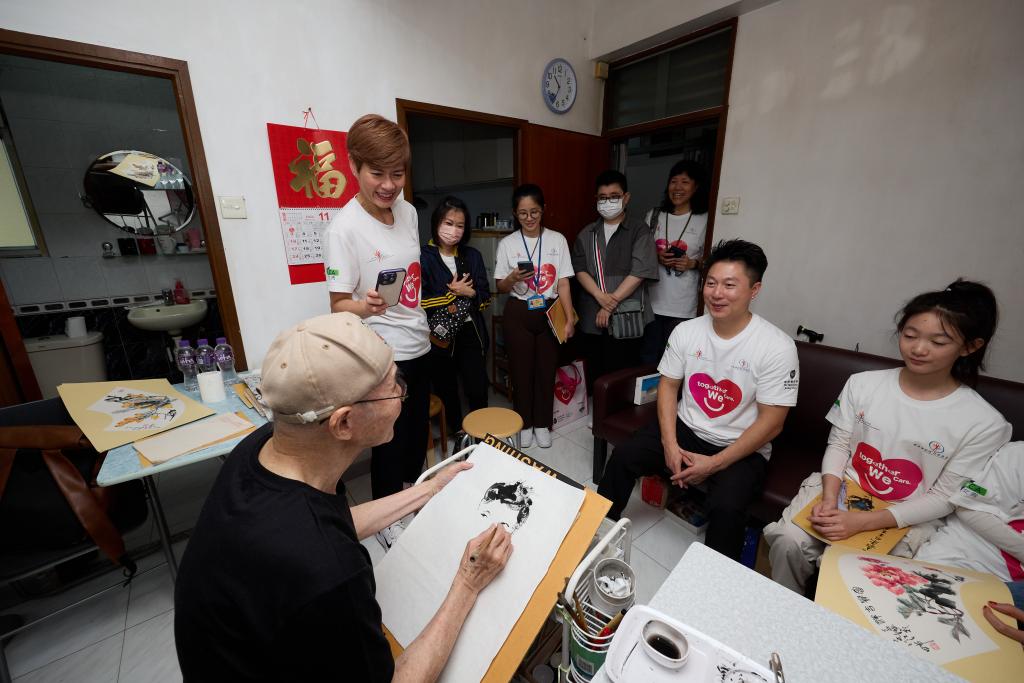 An old man painted portraits for Mr. Li Xiao-peng and his daughter during their visit. 