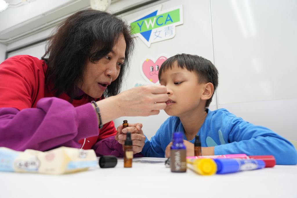 Volunteers assisted the children to blend special aromatherapy massage oil for their mothers.