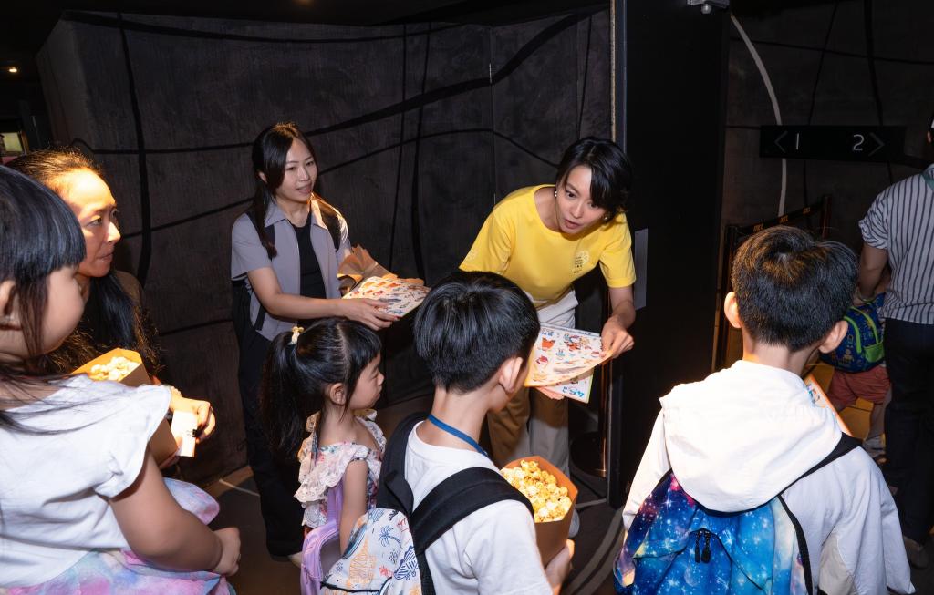 Gigi, who loves children, warmly handed out stickers to the children as they entered the cinema.