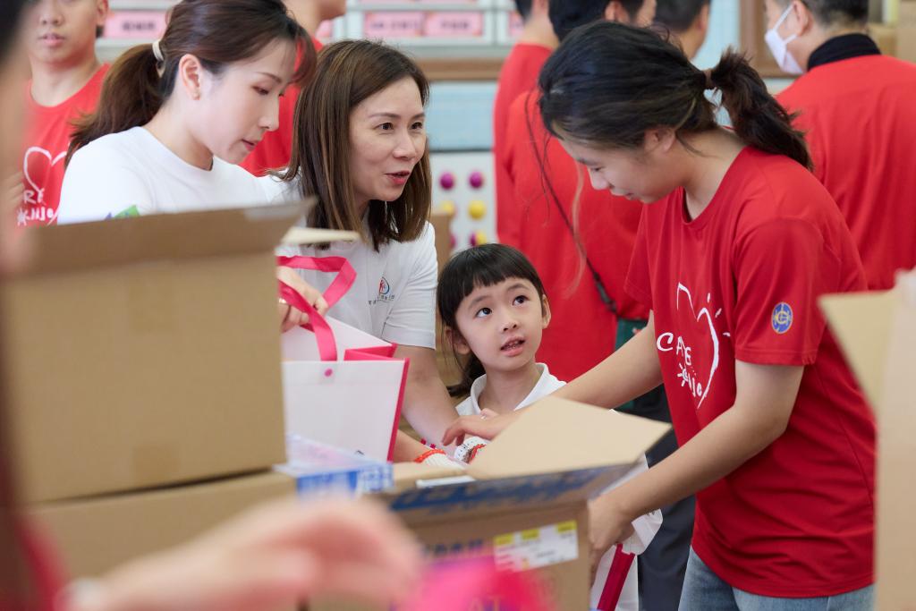 The kid volunteer was attentive to instructions, working together with her family and friends to pack gift bags.