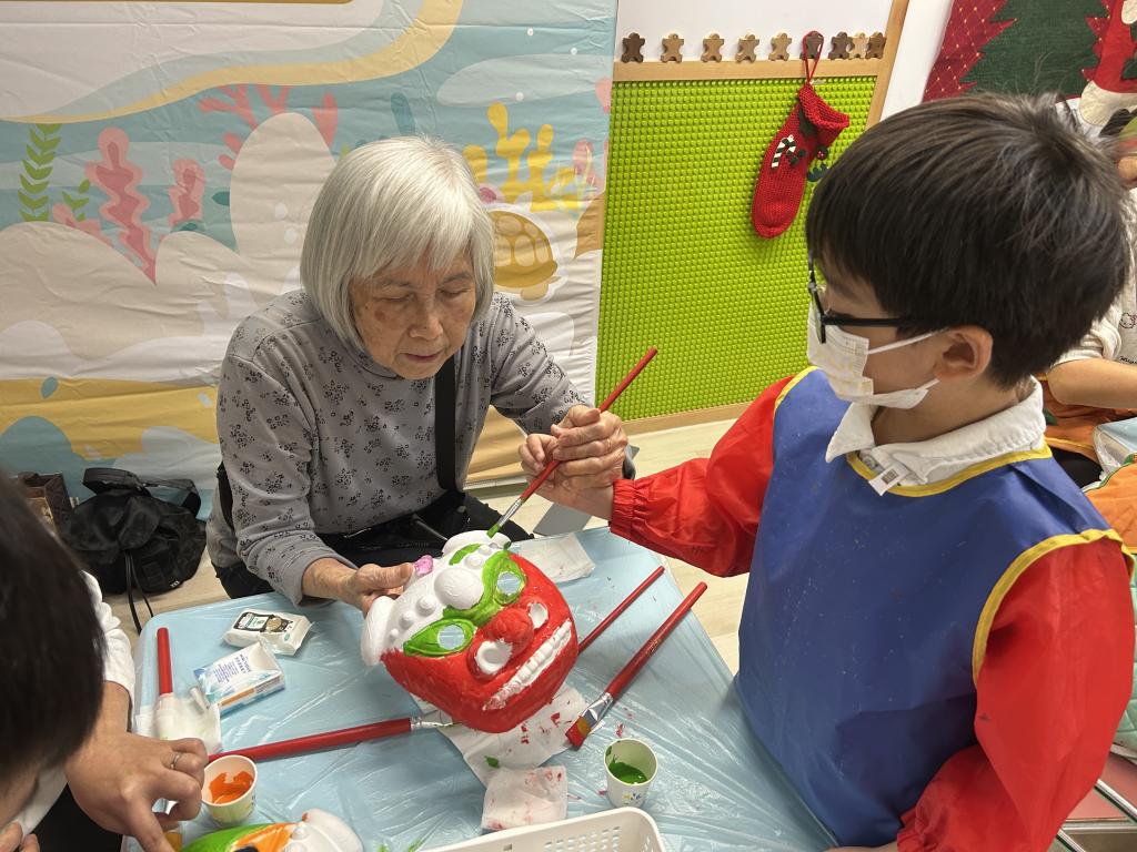 While crafting the traditional lion head, grandparent and grandson shared laughter and conversation, enjoying the fun of handcrafting.