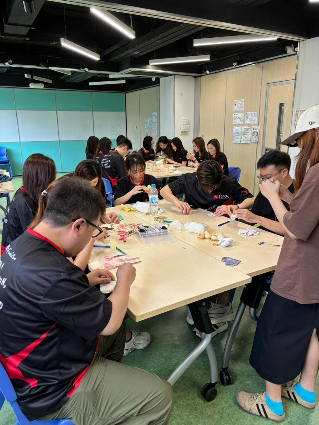 女青年青媽媽指導一眾星展義工親手縫製心型匙扣，將二手嬰兒衣服升級再造，更加添暖意。