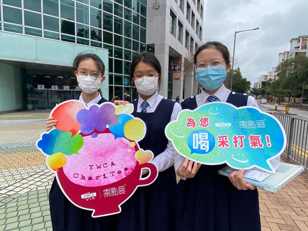 三名女學生於街頭領取茶包並合照