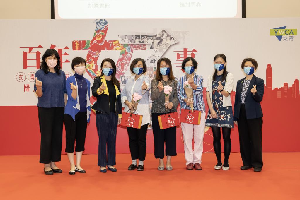 八名女士站在百年女子事的背景板前合照